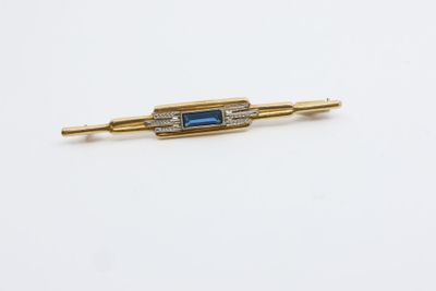 un gros plan d'une broche en pierre dorée et bleue
