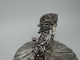 a silver figurine that is sitting on top of a table