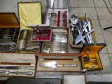 a lot of silverware in a box on the floor