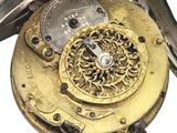 a close up of a gold pocket watch with a white background