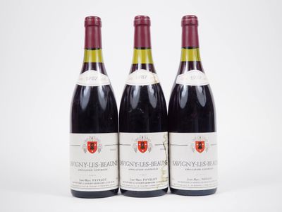 trois bouteilles de vin sont alignées sur une surface blanche