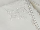 a close up of a white table cloth with a design on it