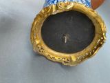 a blue and gold vase with a key in it