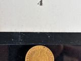 an image of a gold coin sitting on top of a black table