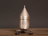 a silver metal object sitting on top of a wooden table