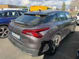 the rear end of a gray car parked in a parking lot