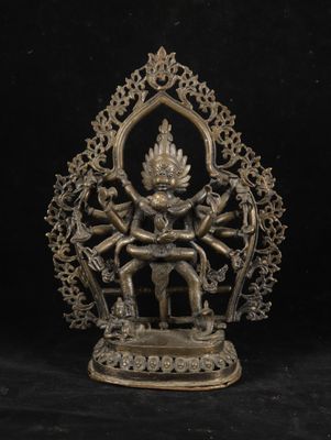 a bronze statue of a person sitting on a throne