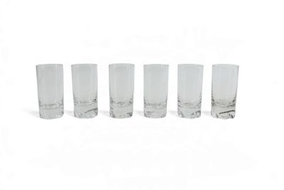 quatre verres transparents sont alignés sur une surface blanche