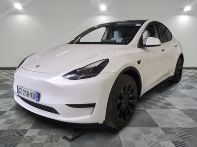 the white tesla model x is parked in the garage