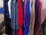 a lot of clothes hanging on a rack in a room