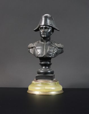 un buste en bronze représentant un homme portant un casque, posé sur une table