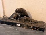 a statue of a cat and a dog on a marble base