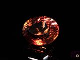 un gros plan d'un diamant posé sur une surface noire, avec une paire de ciseaux