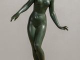 statue of a woman standing on a base on a table