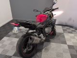a red motorcycle parked in a room with a checkered floor