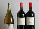 trois bouteilles de vin posées sur une table, l'une à côté de l'autre