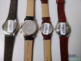 four different watches are lined up on a white surface