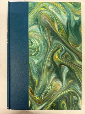 un livre avec une couverture bleue ornée d'un motif en spirale vert