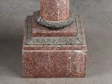 a statue of a man with a hat on top of a pedestal