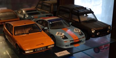 Plusieurs petites voitures sont exposées dans une vitrine.