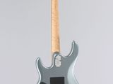 an electric guitar hanging from a string on a white wall