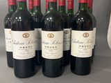 six bouteilles de vin rouge sont alignées sur une table