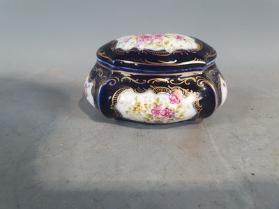 une image représentant une boîte bleue et blanche ornée de fleurs roses
