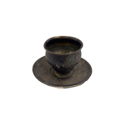 une tasse et une soucoupe sur une soucoupe sur une surface blanche
