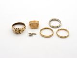 trois bagues en or et une bague en argent sur un fond blanc