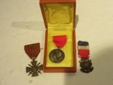 une petite boîte contenant une médaille et sur laquelle est posée une médaille