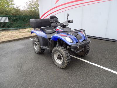 une photo d'un quad bleu garé sur un parking