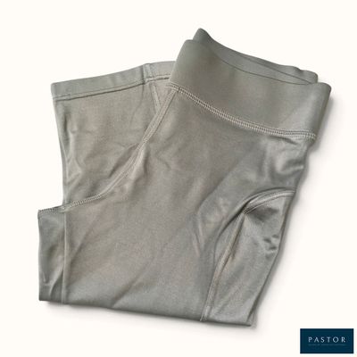 le bas d'un pantalon gris posé sur une surface blanche