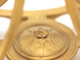 a close up of a gold clock on a white surface