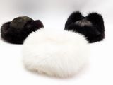 deux bonnets en fourrure noirs et blancs posés sur une surface blanche