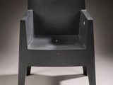 chair made of black plastic with a black seat and armrest