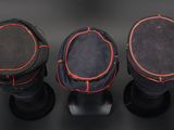 three black and red drum heads on a black surface