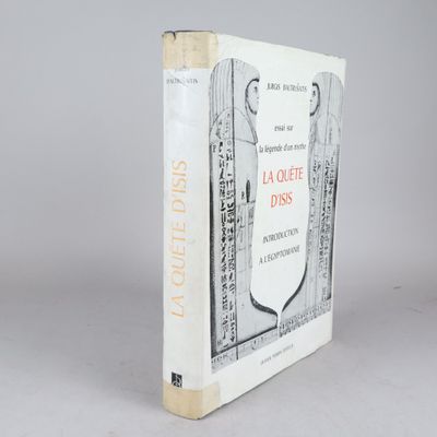 un vieux livre posé sur une table à côté d'un mur blanc