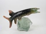 figurine of a fish on a rock on a white background