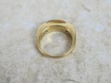 a close up of a gold ring on a marble surface