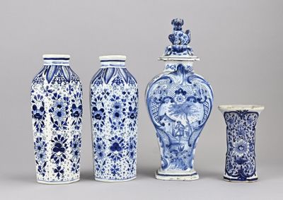 quatre vases bleus et blancs sont alignés sur un fond gris