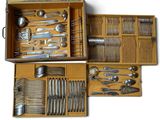 many different types of silverware in a wooden box
