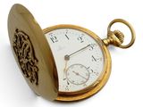 une montre de poche en or posée sur une surface blanche