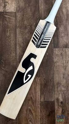 a close up of a cricket bat on a wooden floor