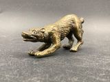 a close up of a bronze figurine of a dog on a table