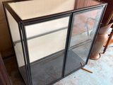 a glass display case in the corner of a room