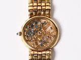 a gold watch that is on a white surface
