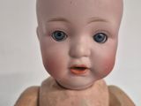 a small doll that is sitting on a white surface
