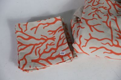 two pieces of cloth with orange designs on them on a white surface