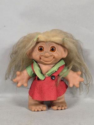 a troll doll with blonde hair wearing a red dress