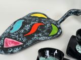a black plate with a colorful fish design on it